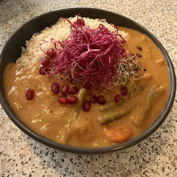 Vegetarische Erdnusssauce mit Reis, Granatapfelkernen und Rote-Bete-Sprossen bei Bakau